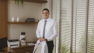 Dr. Caio de Mílio no consultório com equipamentos